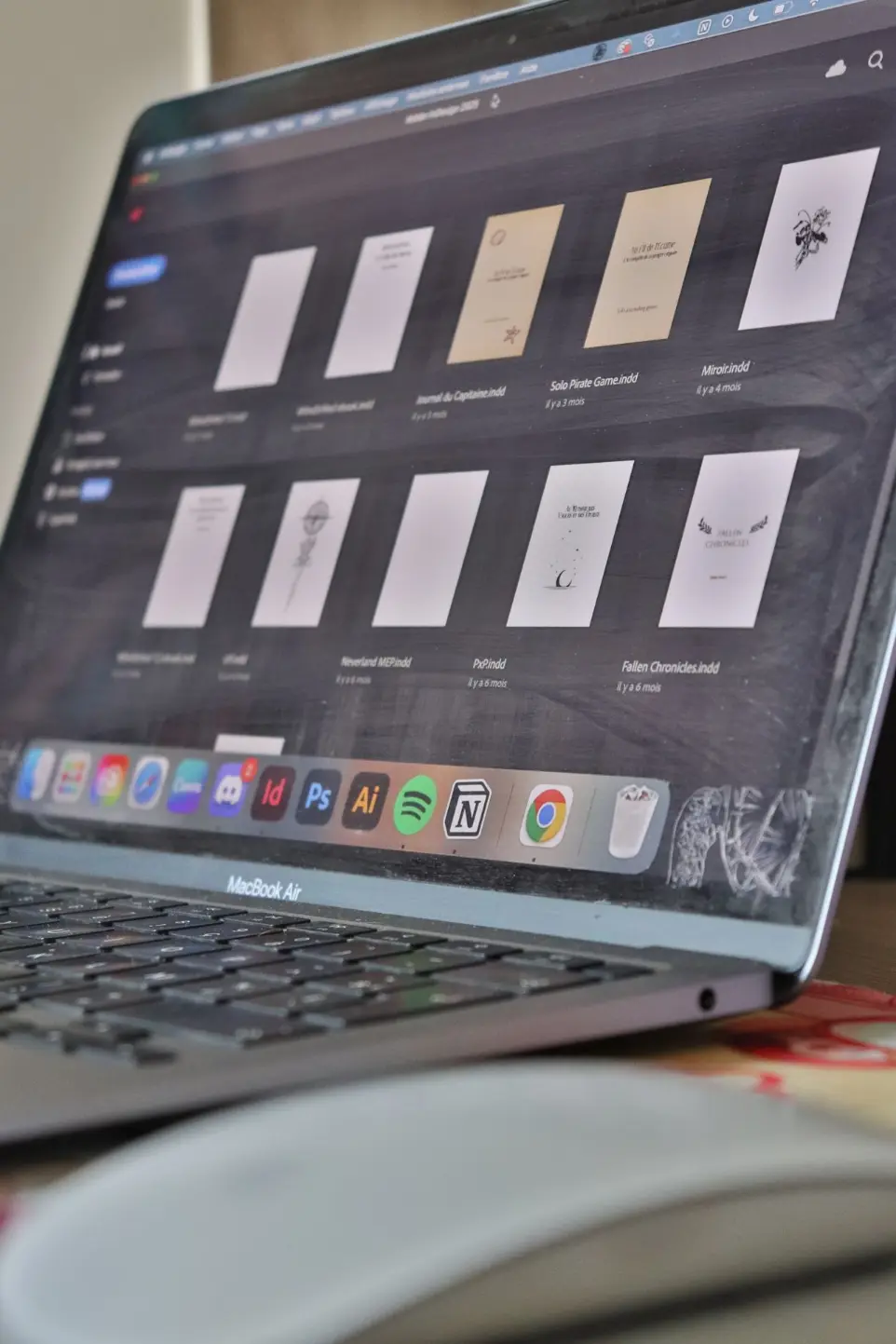 Ordinateur avec InDesign d&#39;ouvert et des exemples de mises en page